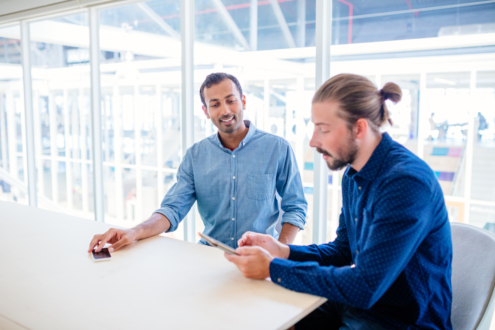 Two male co-workers discuss IRS payment plans in a conference room.