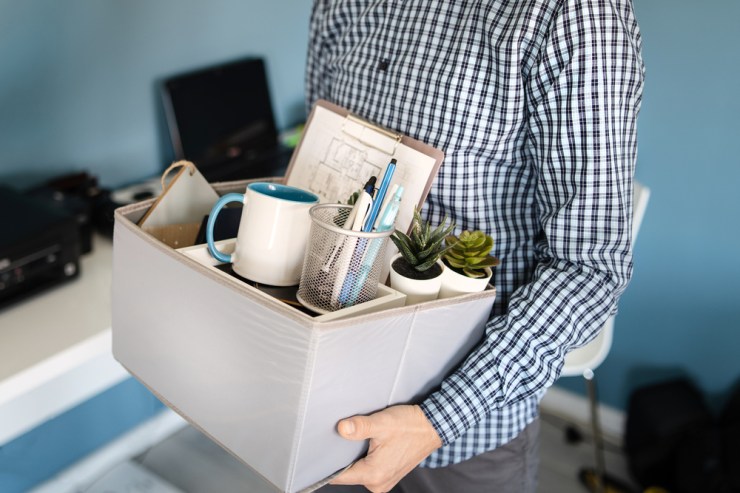 Employee leaving their office with a box of stuff after being fired.