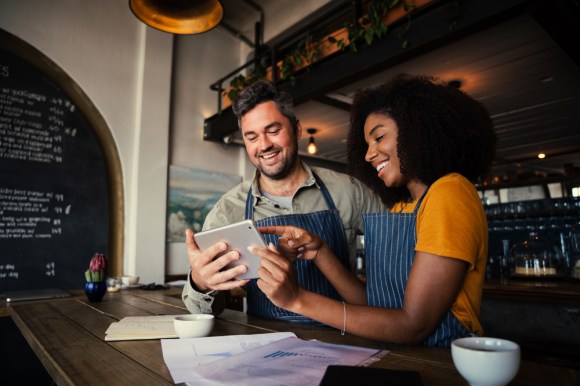 Business partners talking and looking at a tablet