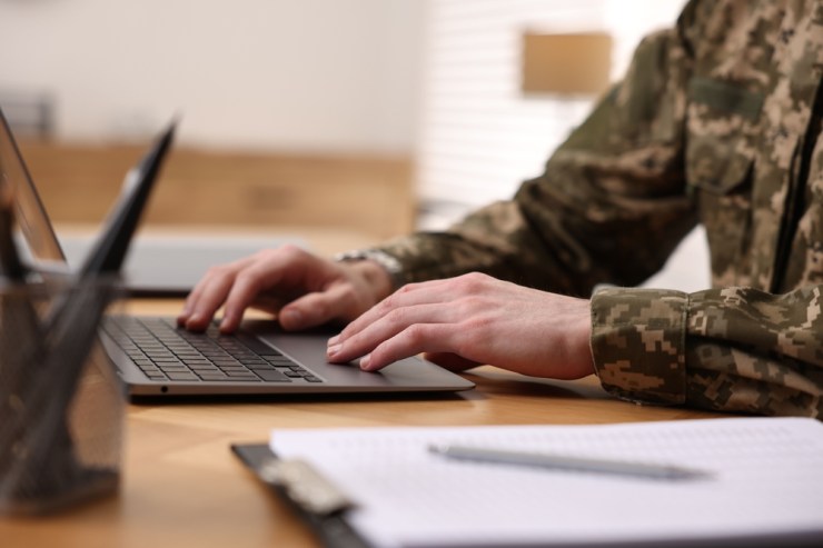 Close-up of a military service member using a laptop.