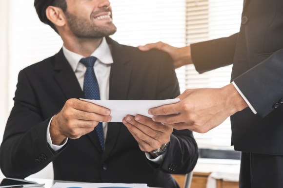 Man accepting a bonus check from boss.