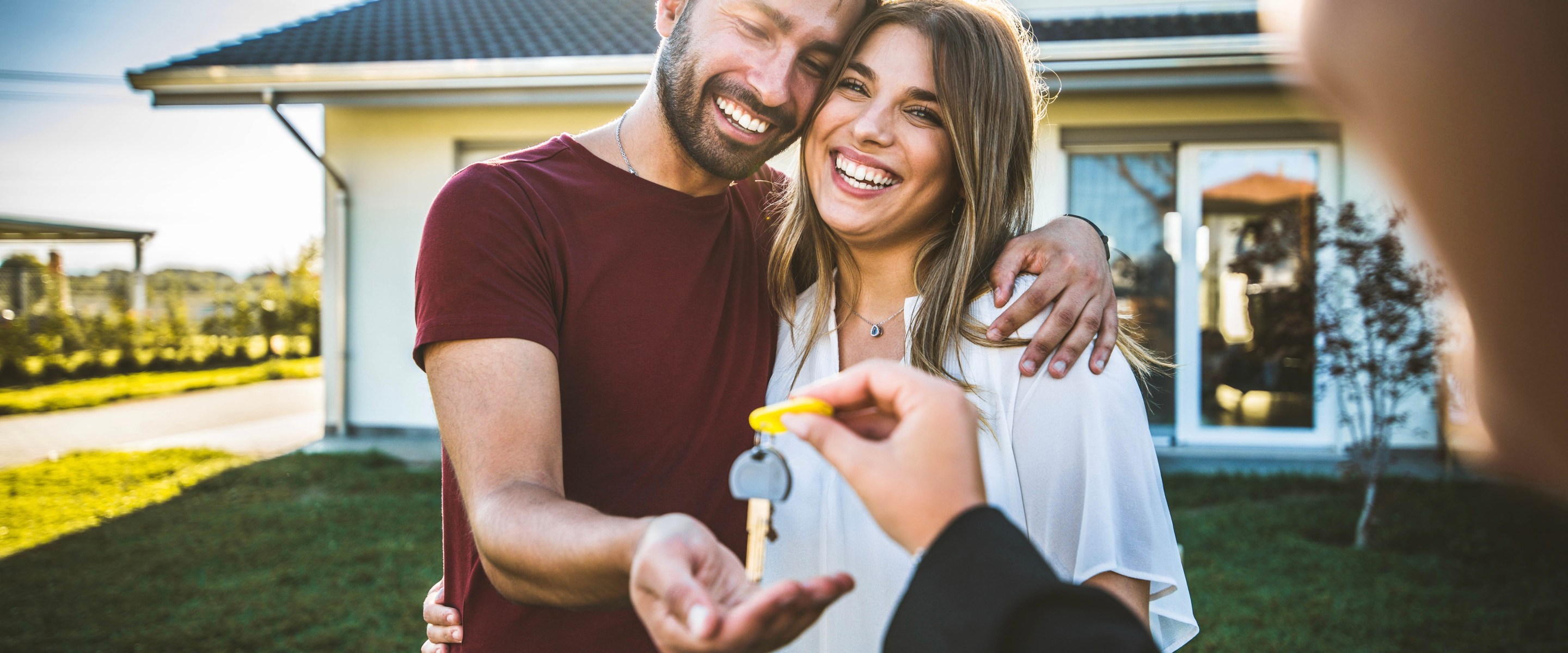 Happy couple receiving keys from realtor.