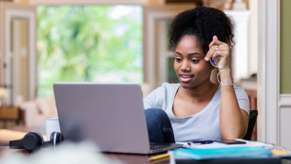 Woman holding glasses on computer