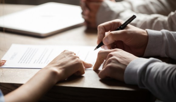 Close-up of two people reviewing a loan document.