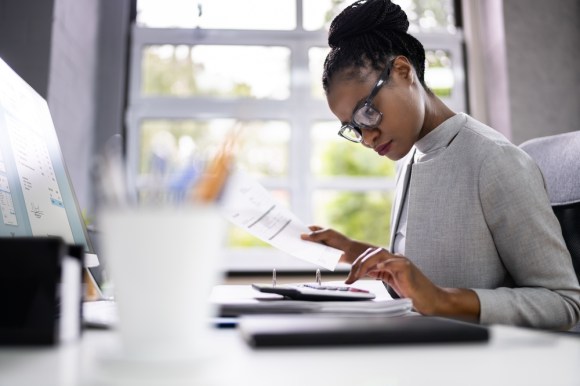 Young Black business woman doing calculations.