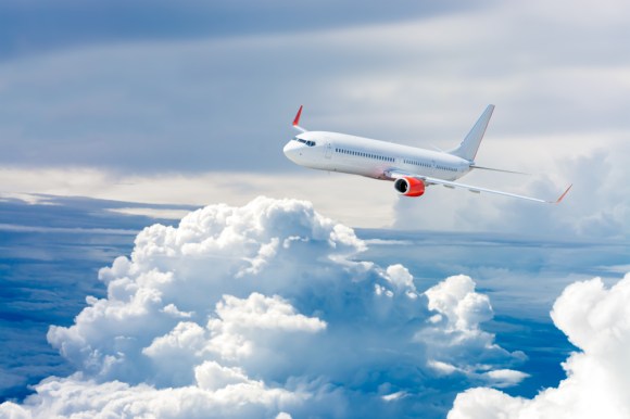 White airplane flying above the clouds