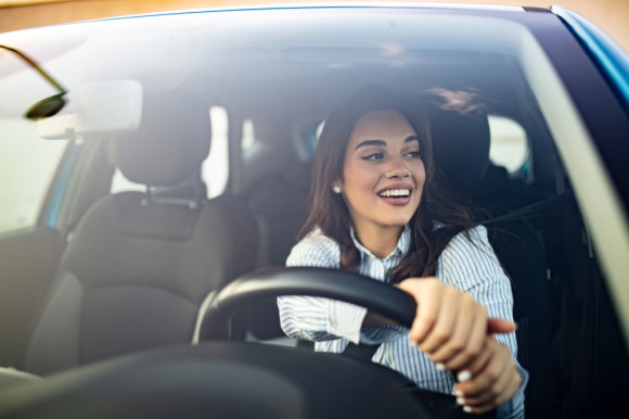 Young brunette businesswoman driving.