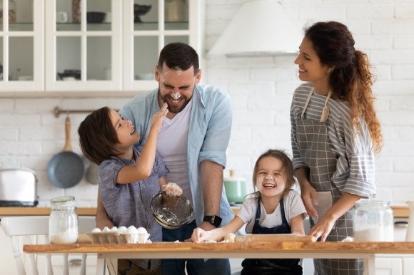 Young family of four baking in the kitchen.
