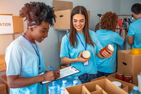 Group of volunteers sort donations during food drive.