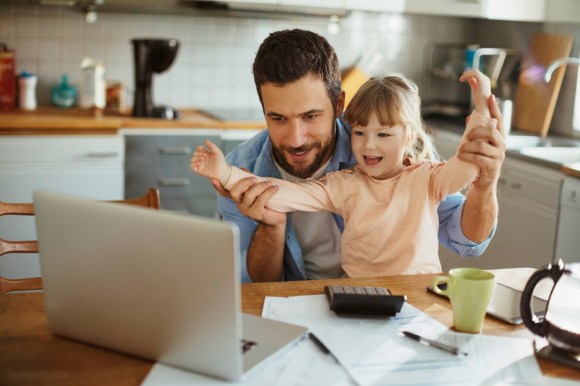 Father and daughter sitting at kitchen table while he does tax prep.