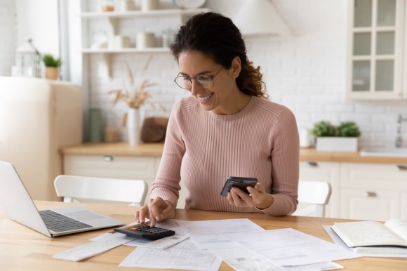 Woman calculating finances on a calculator.