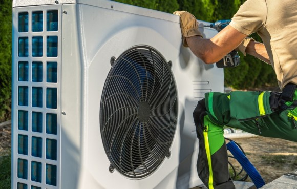 Worker installing energy saving heat pump.