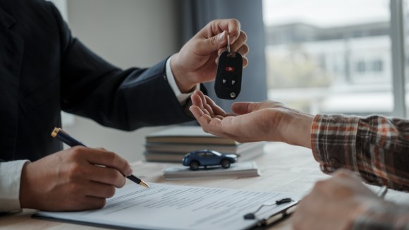 Salesman handing over keys to a car.