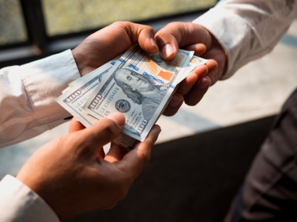 Two men exchanging cash.