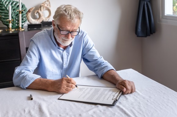 Senior man filling out paperwork.