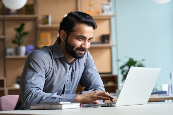 Man working on his laptop in home office.
