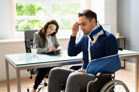 Injured man in a wheelchair filing a claim.