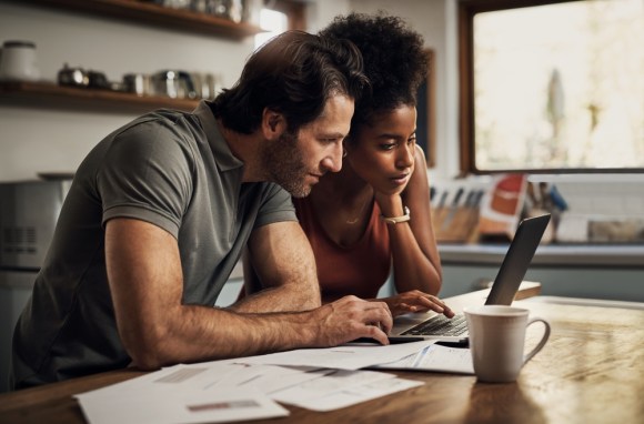 Couple sitting at the kitchen table reviewing finances.
