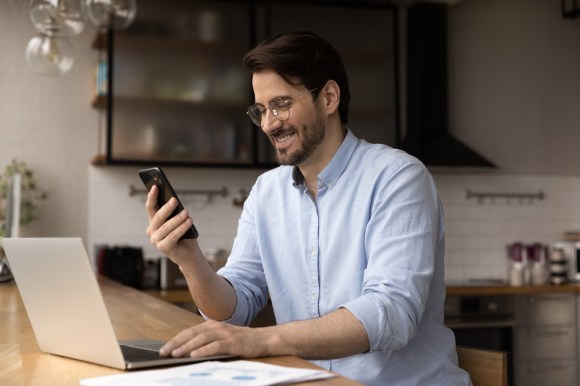 Man using his phone and reviewing information about investments.