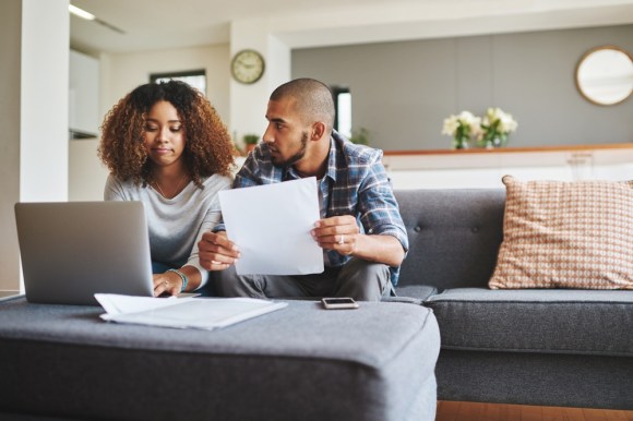 Young interracial couple reviewing documents together.