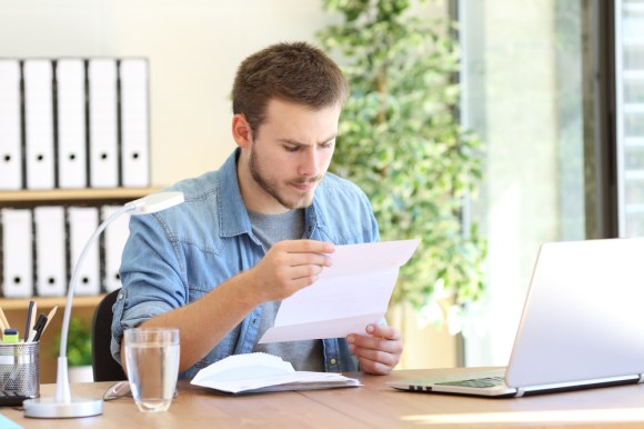 Man opening mail and reading the document.