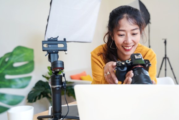 Young Asian woman looking at camera with studio set up behind her.