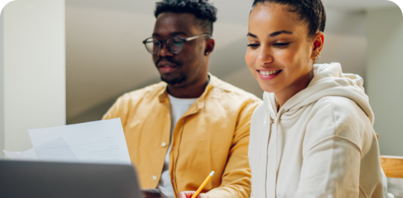 Photo of a man and woman using a computer and completing paperwork