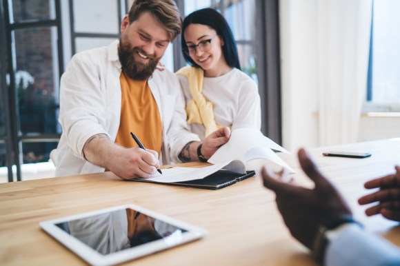Couple signing off on a mortgage loan.